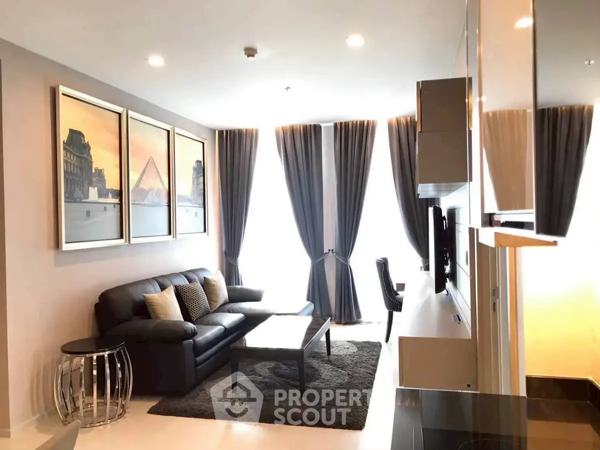 Modern living room with sleek black sofa, elegant curtains, and stylish decor in a bright apartment.