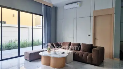 Modern living room with stylish brown sofa and marble coffee tables, large window view