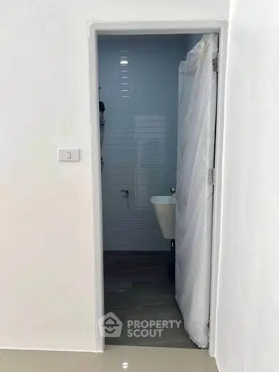 Minimalist bathroom with white walls and simple fixtures, ideal for compact spaces.