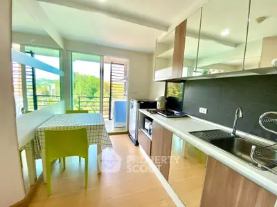 Modern kitchen with open layout and balcony view, featuring sleek appliances and dining area.
