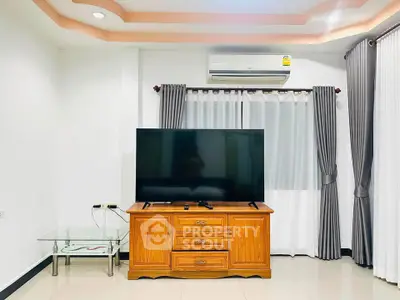 Modern living room with large TV, wooden cabinet, and air conditioning unit.
