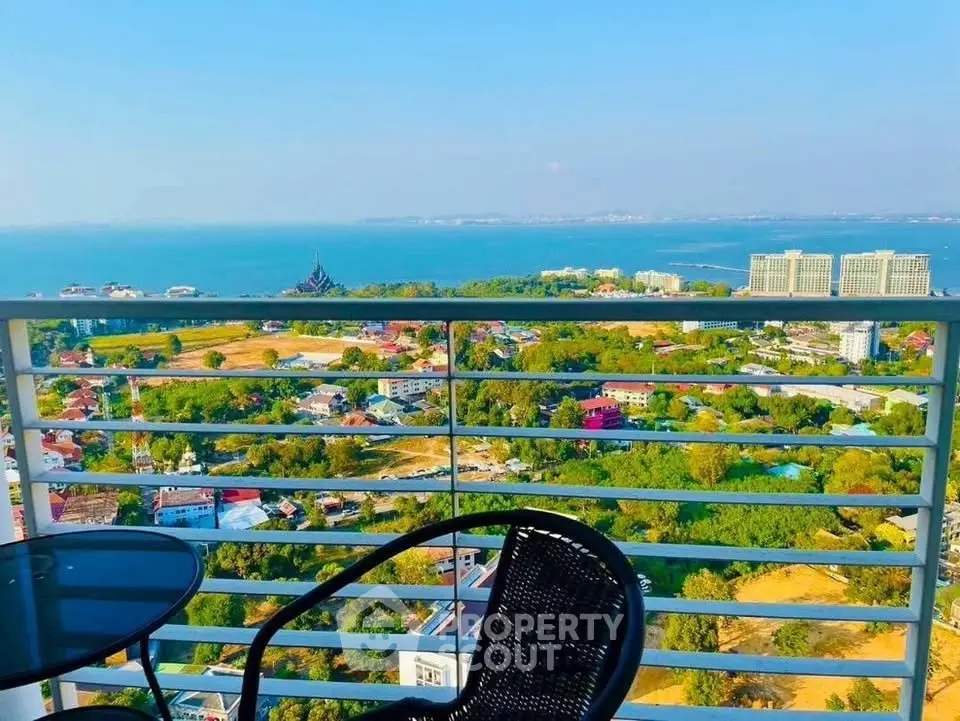 Stunning balcony view overlooking lush greenery and ocean horizon, perfect for relaxation.