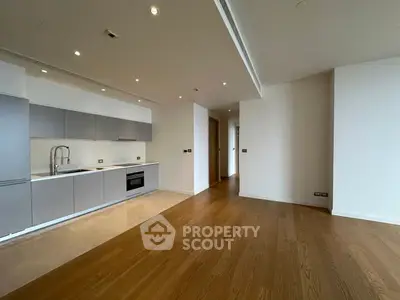 Spacious modern kitchen with sleek cabinetry and hardwood floors in open layout.