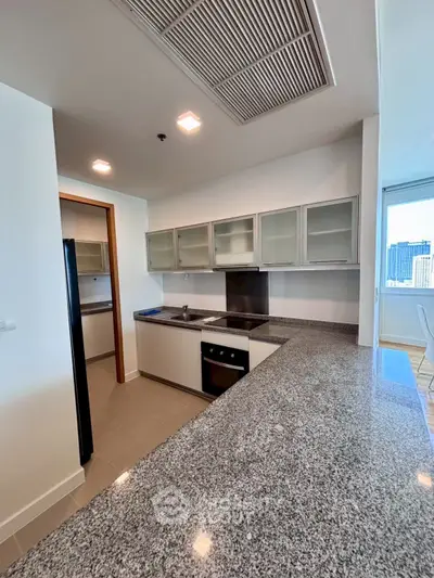Modern kitchen with granite countertops and sleek appliances in a high-rise apartment.