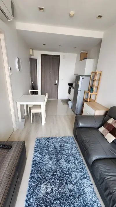 Modern living room with open kitchen, stylish furniture, and cozy decor in a contemporary apartment.
