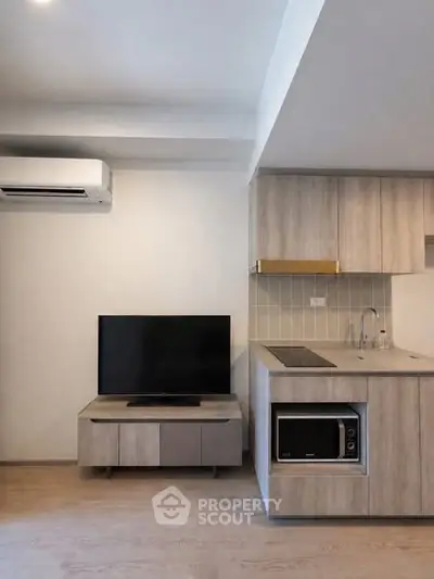 Modern kitchen and living area with sleek cabinetry and built-in appliances.