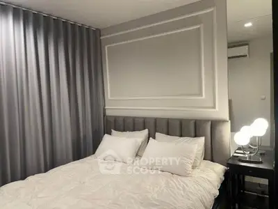 Elegant bedroom with plush headboard and modern lighting, perfect for a cozy retreat.
