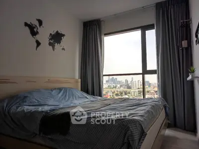 Cozy bedroom with city view, featuring a stylish bed and world map wall art.