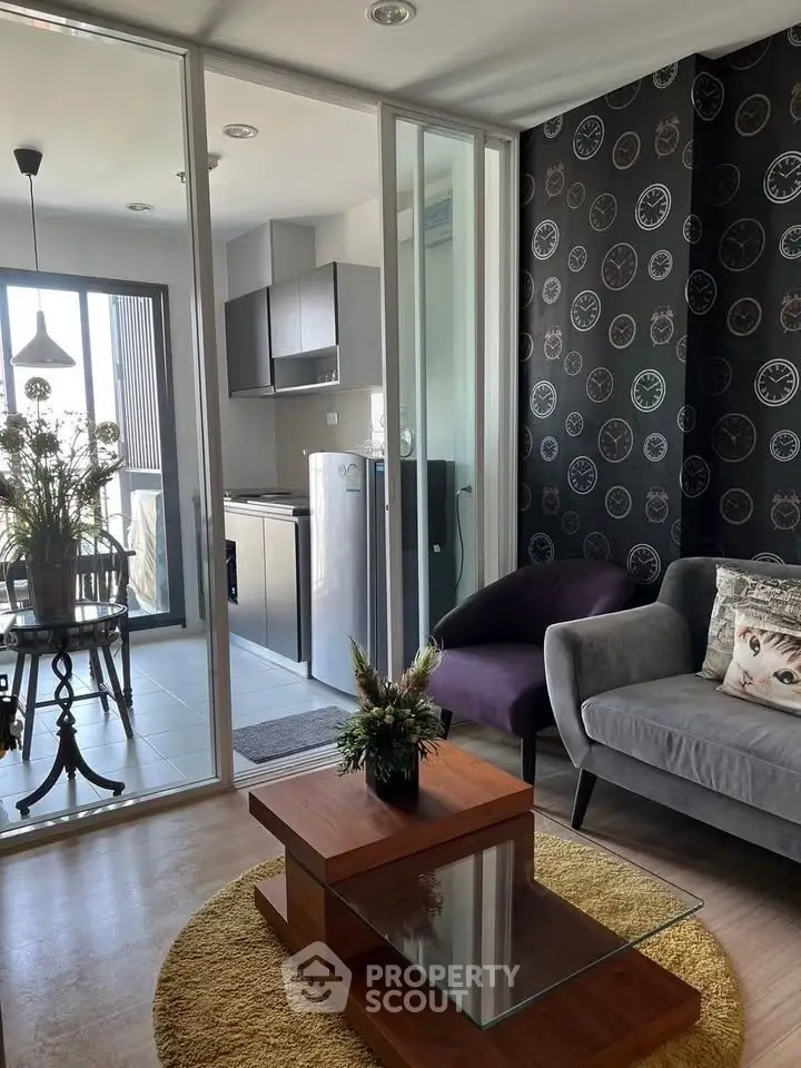 Modern living room with stylish decor and open kitchen layout, featuring elegant furniture and natural light.