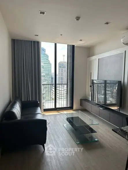 Modern living room with city view, sleek furniture, and floor-to-ceiling windows in urban apartment.