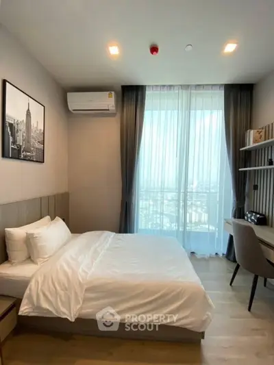 Modern bedroom with city view, featuring a cozy bed and stylish decor.