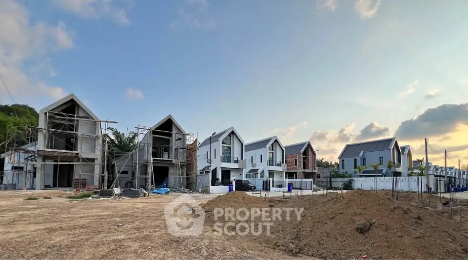 Modern residential development with contemporary houses under construction, showcasing sleek architecture and spacious layouts.