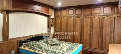 Spacious bedroom with elegant wooden wardrobes and cozy bed