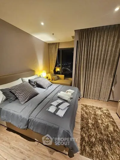 Luxurious bedroom with elegant decor and city view, featuring cozy bedding and ambient lighting.