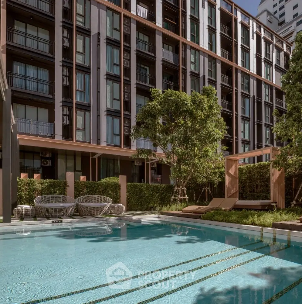 Luxurious apartment complex with serene pool and lush greenery