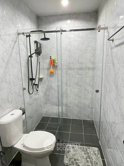 Modern bathroom with glass shower enclosure and tiled walls