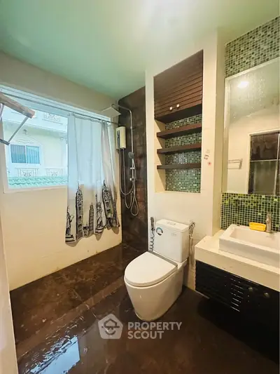 Modern bathroom with sleek fixtures and stylish design, featuring a shower and a contemporary sink area.
