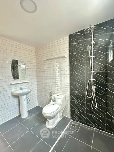 Modern bathroom with sleek black and white tiles and contemporary fixtures.