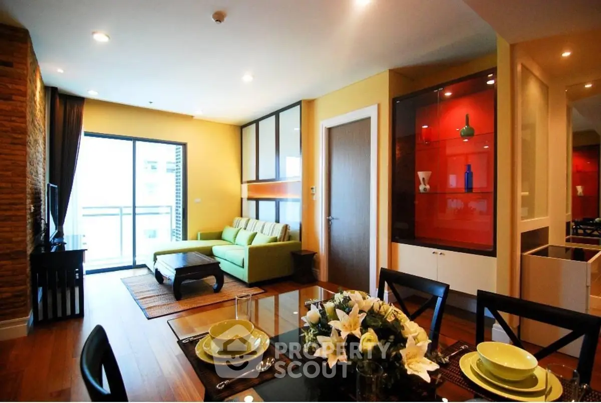 Modern living room with stylish decor and open layout, featuring a cozy green sofa and elegant dining area.