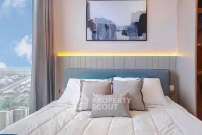 Modern bedroom with stylish decor and stunning city view from the window.