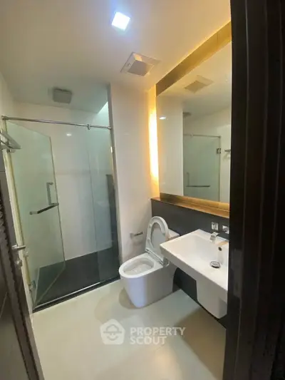 Modern bathroom with glass shower and sleek fixtures in a contemporary home.