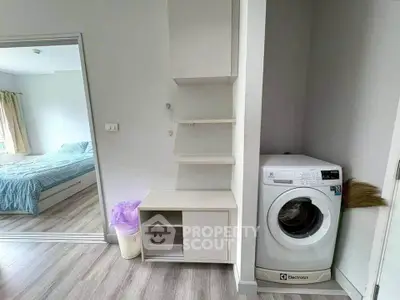 Modern apartment interior with washing machine and bedroom view