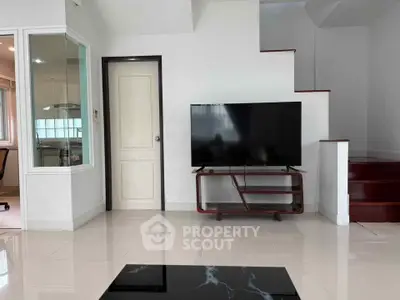 Modern living room with sleek TV setup and glossy tiled floors