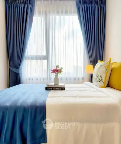 Cozy bedroom with elegant blue curtains and stylish decor, perfect for relaxation and comfort.