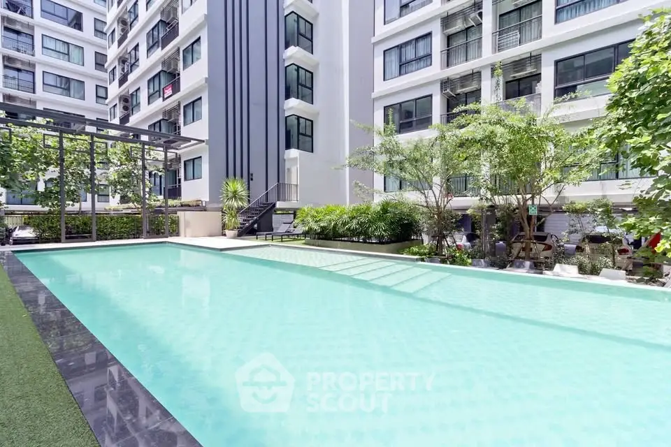 Luxurious apartment complex with a pristine outdoor pool and lush greenery.