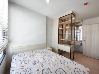 Modern bedroom with stylish shelving and natural light, perfect for cozy living.