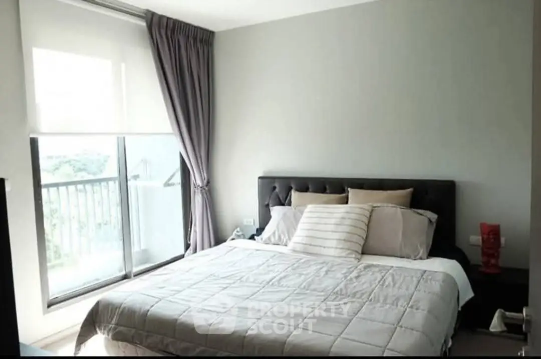 Spacious bedroom with large window and balcony access in modern apartment