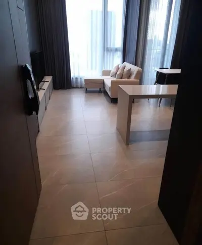 Modern living room with large windows and stylish furniture in a high-rise apartment.