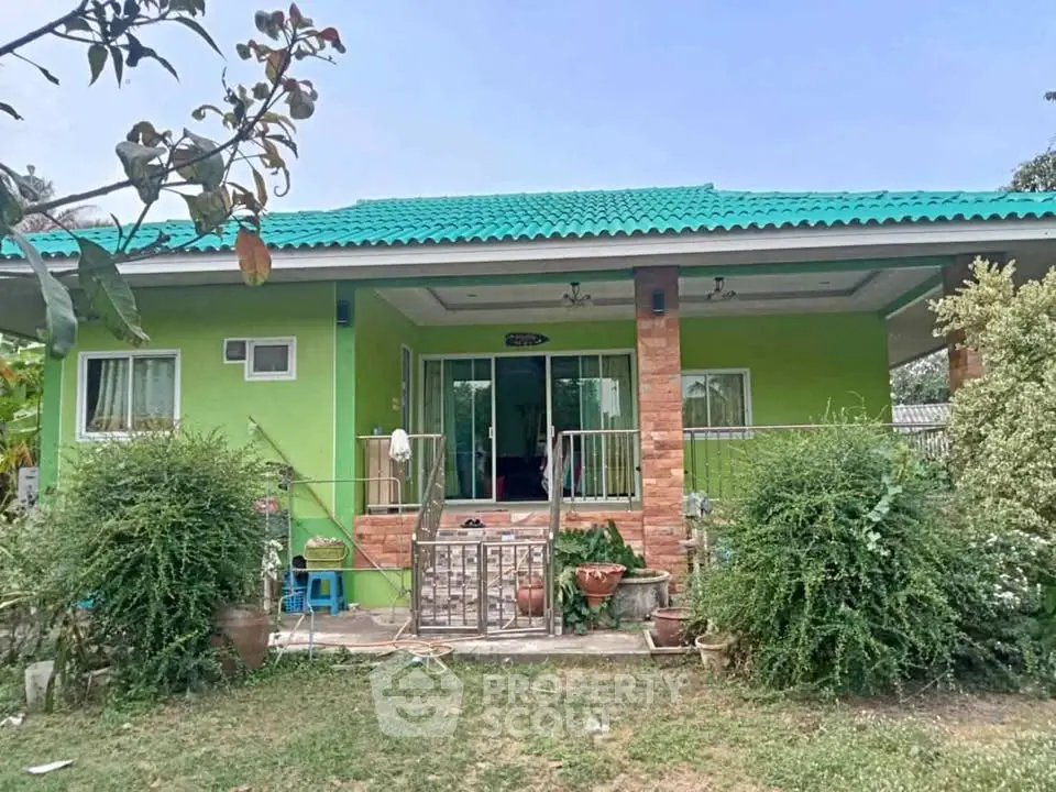 Charming green house with vibrant garden and inviting entrance