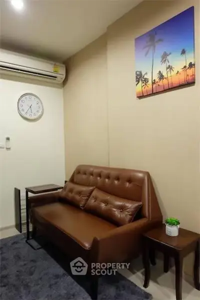 Cozy living room with leather sofa and wall art, perfect for relaxation.