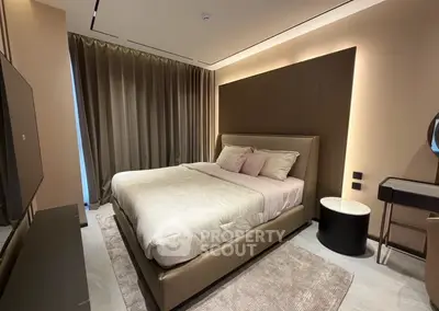 Luxurious modern bedroom with elegant decor and ambient lighting, featuring a plush bed and stylish furnishings.