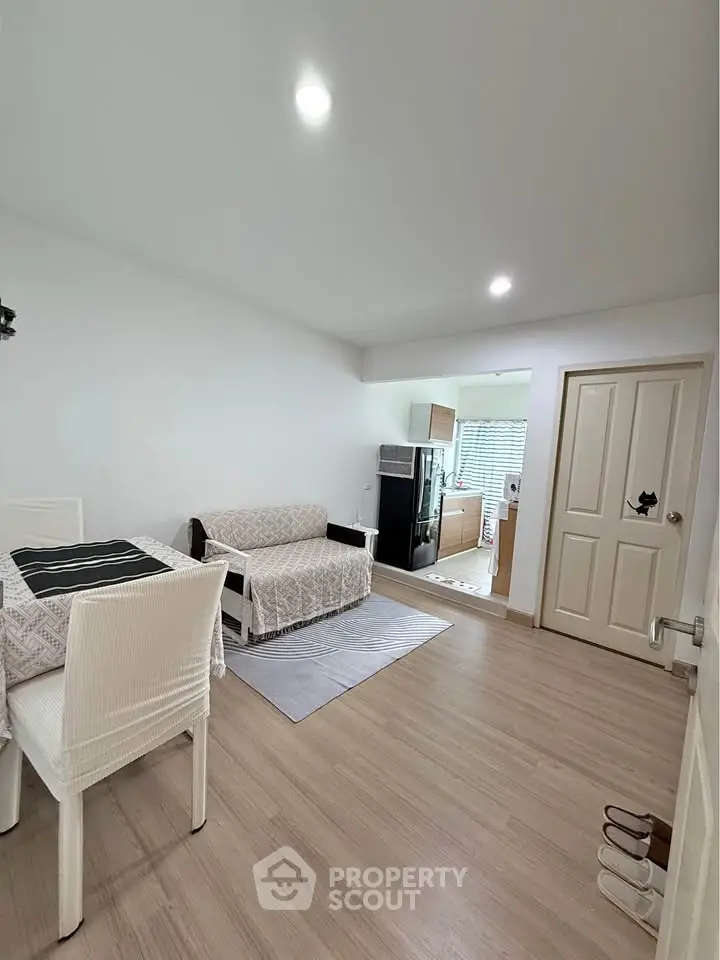 Spacious living room with modern decor and open kitchen layout in a cozy apartment.