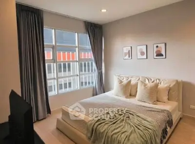 Cozy bedroom with modern decor and large window offering city view