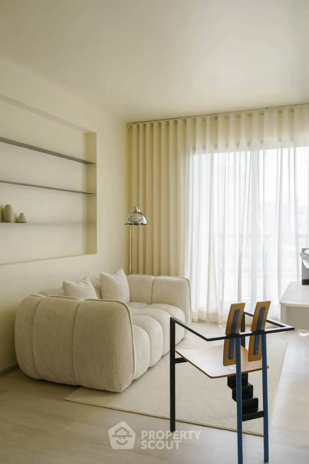Modern living room with plush sofa, stylish shelving, and floor-to-ceiling windows for natural light.
