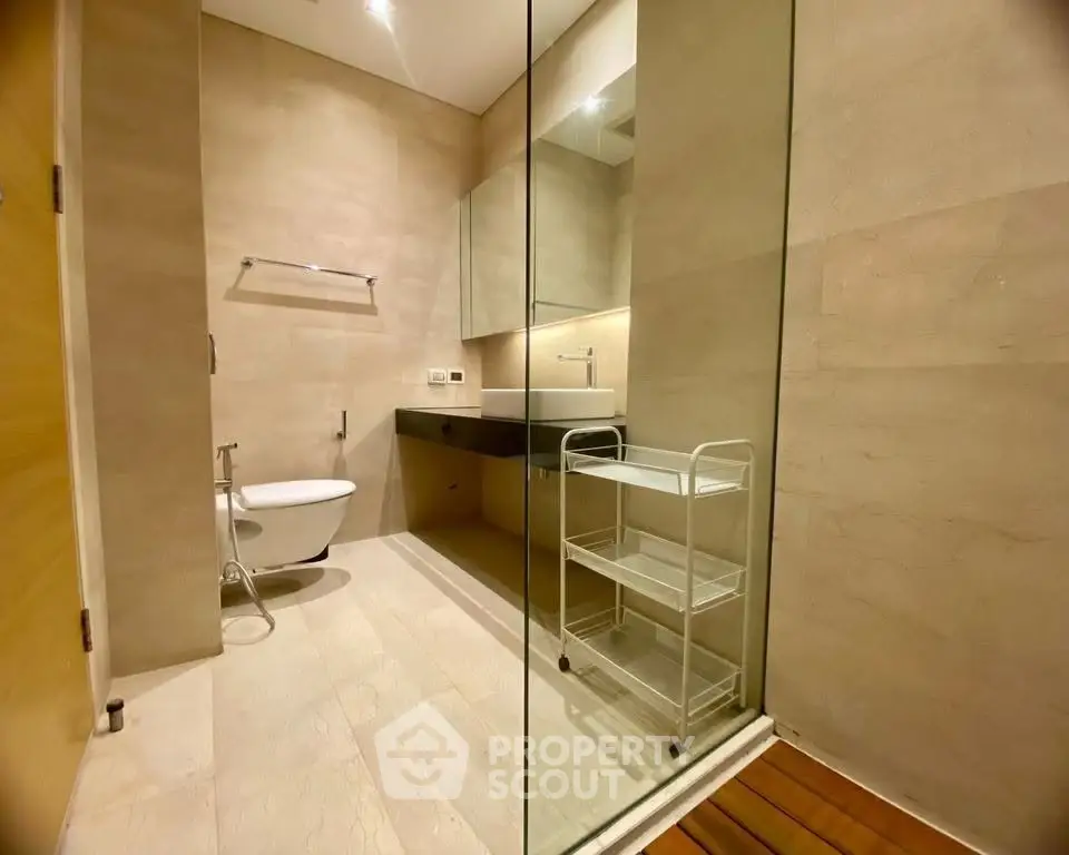 Modern bathroom with sleek design and glass partition in luxury real estate property.
