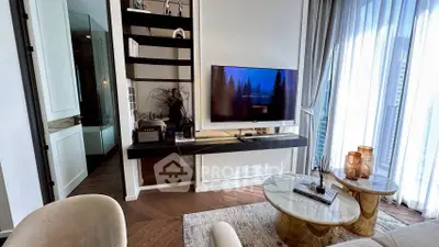 Modern living room with elegant decor and large windows offering natural light.