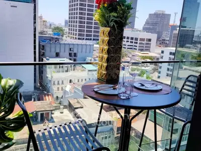 Chic urban balcony with city view, perfect for dining and relaxation.
