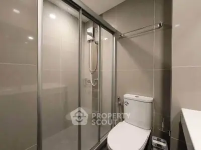 Modern bathroom with sleek shower and toilet in contemporary apartment.
