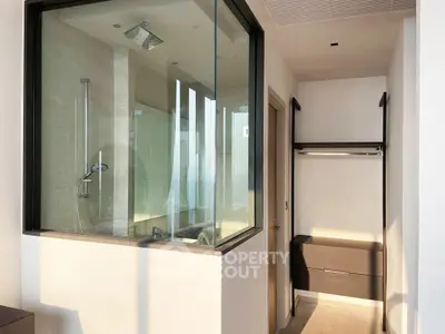 Modern bathroom with glass shower enclosure and sleek storage unit