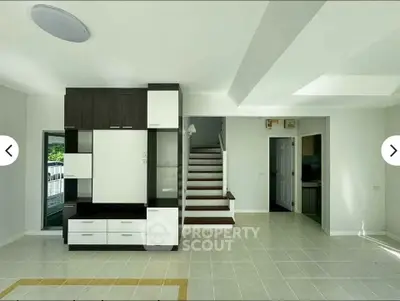 Spacious modern living room with sleek built-in storage and elegant staircase