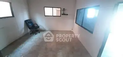 Spacious unfurnished room with large windows and office chair, ideal for customization.