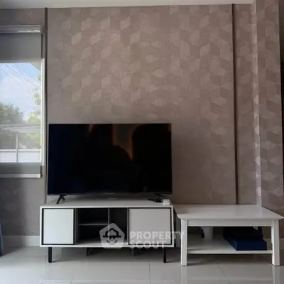 Modern living room with stylish TV stand and geometric wallpaper, perfect for contemporary home decor.