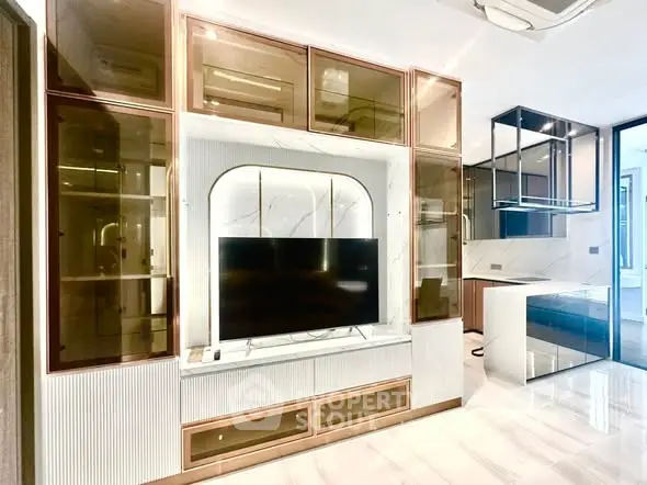 Luxurious modern living room with sleek built-in entertainment center and stylish glass cabinets.