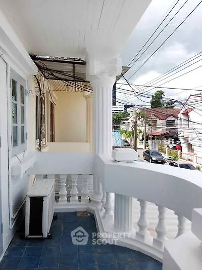 Charming balcony with classic columns and city view, perfect for relaxation.