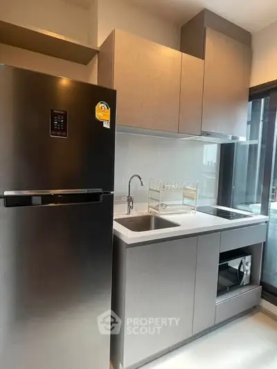 Modern kitchen with sleek cabinetry and stainless steel appliances in a contemporary apartment.
