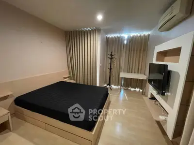 Modern bedroom with sleek design, featuring a comfortable bed, wall-mounted TV, and elegant curtains.